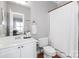 Bright bathroom featuring a white vanity, toilet, and shower-tub with a white curtain at 5730 Closeburn Rd # N, Charlotte, NC 28210