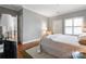 Cozy bedroom featuring neutral tones, a large window, and hardwood floors at 5730 Closeburn Rd # N, Charlotte, NC 28210