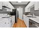 Galley kitchen with white cabinets, stainless steel dishwasher, and hardwood floors at 5730 Closeburn Rd # N, Charlotte, NC 28210