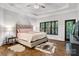 Bright bedroom with hardwood floors, a tray ceiling, and a crystal ceiling fan at 6327 Fox Tail Ln, Davidson, NC 28036