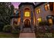 Inviting front entrance featuring stone accents, an elegant doorway with a chandelier, and manicured landscaping at 6327 Fox Tail Ln, Davidson, NC 28036