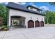 Spacious three-car garage with arched wooden doors and ample parking space leading to the main house at 6327 Fox Tail Ln, Davidson, NC 28036