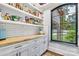 Bright pantry with white cabinets, wood countertop, open shelving and a window at 6327 Fox Tail Ln, Davidson, NC 28036