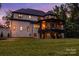 Back of a stately home featuring a covered patio, brick exterior, and well-maintained lawn at 6327 Fox Tail Ln, Davidson, NC 28036