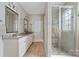 Bright bathroom with double sinks, granite countertops, a glass-enclosed shower, and neutral tile flooring at 732 Wood Lily Dr, Belmont, NC 28012