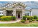 Inviting front door with stone accents and a charming wreath, surrounded by manicured landscaping at 732 Wood Lily Dr, Belmont, NC 28012