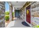 Inviting front porch with stone pillars, a cozy seating area, and a decorative front door at 732 Wood Lily Dr, Belmont, NC 28012