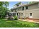 View of home's back elevation with screened in porch overlooking a beautiful lawn and landscaping at 8300 Quarters Ln, Mint Hill, NC 28227