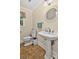 Powder room featuring a pedestal sink and decorative mirror, with a window providing natural light at 8300 Quarters Ln, Mint Hill, NC 28227