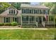 Charming two-story home with covered porch, blue shutters, landscaped yard, and American flag at 8300 Quarters Ln, Mint Hill, NC 28227