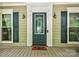 Inviting front porch with decorative glass door, sconces, and blue shutters at 8300 Quarters Ln, Mint Hill, NC 28227