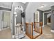 Hallway featuring a decorative mirror, staircase with wooden banister, and access to rooms at 8300 Quarters Ln, Mint Hill, NC 28227