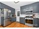 Updated kitchen with stainless steel appliances, gray cabinets, and hardwood floors at 8300 Quarters Ln, Mint Hill, NC 28227