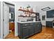 Modern kitchen with sleek dark cabinets, floating shelves, and hardwood flooring at 8300 Quarters Ln, Mint Hill, NC 28227