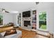 Bright living room with brick fireplace, built-in bookshelves, and hardwood floors at 8300 Quarters Ln, Mint Hill, NC 28227