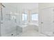 Bright bathroom with glass enclosed shower and a tub with marble surround at 837 Kathy Dianne Dr, Indian Land, SC 29707