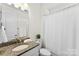 Well-lit bathroom features a granite countertop, white cabinets, a vanity mirror, and a shower with curtain at 837 Kathy Dianne Dr, Indian Land, SC 29707