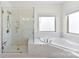 Marble bathroom with a glass shower and large tub under a window at 837 Kathy Dianne Dr, Indian Land, SC 29707