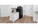Well-lit kitchen with white cabinetry, granite countertops, and a black refrigerator at 8416 Highgate Dr, Charlotte, NC 28215