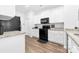 Modern kitchen with white cabinetry, black appliances, and wood-look flooring at 8416 Highgate Dr, Charlotte, NC 28215