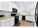 Bright kitchen featuring white cabinets, granite countertops, and modern black appliances at 8416 Highgate Dr, Charlotte, NC 28215