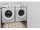 Modern laundry room features Samsung washer and dryer set with neutral rug on dark wood-look floor at 8416 Highgate Dr, Charlotte, NC 28215