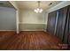 Formal dining area offers sleek wood floors, elegant chandelier, and lots of light at 8904 Daventry Pl, Charlotte, NC 28215