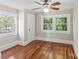 Bright bedroom featuring hardwood floors, fresh paint, updated ceiling fan, and natural light from two windows at 904 Edgewood Cir, Gastonia, NC 28052