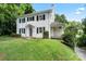 Traditional home featuring black shutters, white siding and a covered porch set amid lush greenery at 904 Edgewood Cir, Gastonia, NC 28052