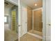 Bathroom showcasing tiled shower with glass door, next to linen closet, and door to bedroom at 9212 John Hawks Rd, Cornelius, NC 28031