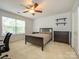 Bedroom features neutral carpet, ceiling fan, window, and closet at 9212 John Hawks Rd, Cornelius, NC 28031