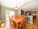 Inviting dining room featuring hardwood floors, a wooden table with seating for six, and a view into the kitchen at 9212 John Hawks Rd, Cornelius, NC 28031