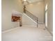 Open living area with a staircase, view into the kitchen, and neutral carpet at 9212 John Hawks Rd, Cornelius, NC 28031