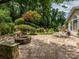 Stone patio featuring a cozy fire pit, outdoor seating, grill, and beautiful landscaping at 9212 John Hawks Rd, Cornelius, NC 28031