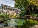Backyard pond and water feature with a lush backyard, stone features and vibrant plant life at 9212 John Hawks Rd, Cornelius, NC 28031