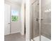 Modern bathroom with a glass-enclosed shower and neutral tile, complemented by a view to the outdoors at 9221 Widden Way, Charlotte, NC 28269