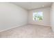 Bright bedroom featuring plush carpet, neutral walls, and a window offering natural light and neighborhood views at 9221 Widden Way, Charlotte, NC 28269