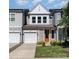 Beautiful new construction townhome features an orange front door, lush lawn, and a one car garage at 9221 Widden Way, Charlotte, NC 28269