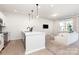 Modern kitchen open to the living space offers stone countertops, stainless steel appliances, and a breakfast bar at 9221 Widden Way, Charlotte, NC 28269