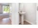 Chic powder room boasts a pedestal sink, stylish mirror, and modern fixtures, conveniently located near living area at 9221 Widden Way, Charlotte, NC 28269