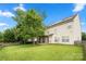 Spacious backyard with a lush lawn, mature trees, a wooden fence, solar panels, and a covered patio area at 9429 Coast Laurel Nw Ave, Concord, NC 28027