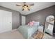 Grey bedroom with plush carpet, large window, ceiling fan, and ensuite bath at 9429 Coast Laurel Nw Ave, Concord, NC 28027