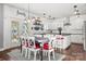 Bright and airy dining area features modern lighting, crisp white cabinets, and a cozy rug underneath a farmhouse table at 9429 Coast Laurel Nw Ave, Concord, NC 28027