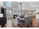 Sunlit living room features vaulted ceiling, fireplace with decorative clock, hardwood floors, and open access to the kitchen at 9429 Coast Laurel Nw Ave, Concord, NC 28027