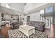 Open-concept living room boasts hardwood floors, stylish sofas, bright light, and view into kitchen and stairway at 9429 Coast Laurel Nw Ave, Concord, NC 28027