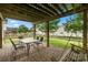 Charming brick patio with a wooden pergola, dining set, and swing creating a cozy outdoor entertaining space at 9429 Coast Laurel Nw Ave, Concord, NC 28027