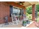 Relaxing front porch featuring rocking chairs, decorative planters, and well-maintained landscaping at 101 Harvest Farm Ct, Mount Holly, NC 28120