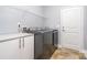 Well-equipped laundry room featuring gray washer and dryer, plus storage and tile floors at 101 Harvest Farm Ct, Mount Holly, NC 28120
