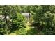 Aerial view of a house among lush trees, with a backyard featuring a paved patio area at 10600 Four Mile Creek Rd, Charlotte, NC 28277