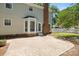 A backyard features a paved patio, bay window, brick chimney, and white picket fence at 10600 Four Mile Creek Rd, Charlotte, NC 28277